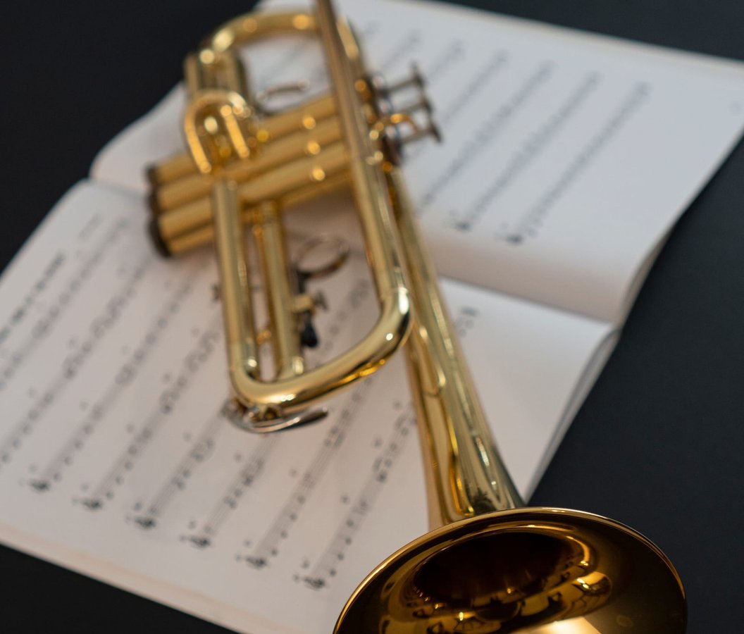 A brass trumpet resting on a page of sheet music